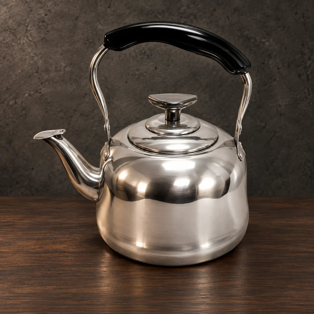 Polished classic stainless steel teapot with a rounded body, curved spout, fitted lid, and black handle grip