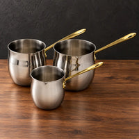 Three double-bottom stainless steel milk cups with gold handles