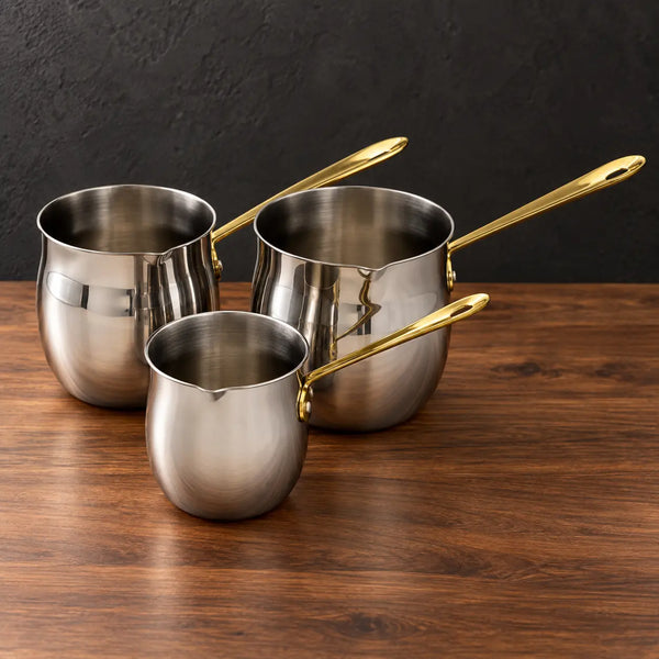 Three double-bottom stainless steel milk cups with gold handles