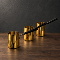 Gold stainless steel milk cups with black handles and optional lids
