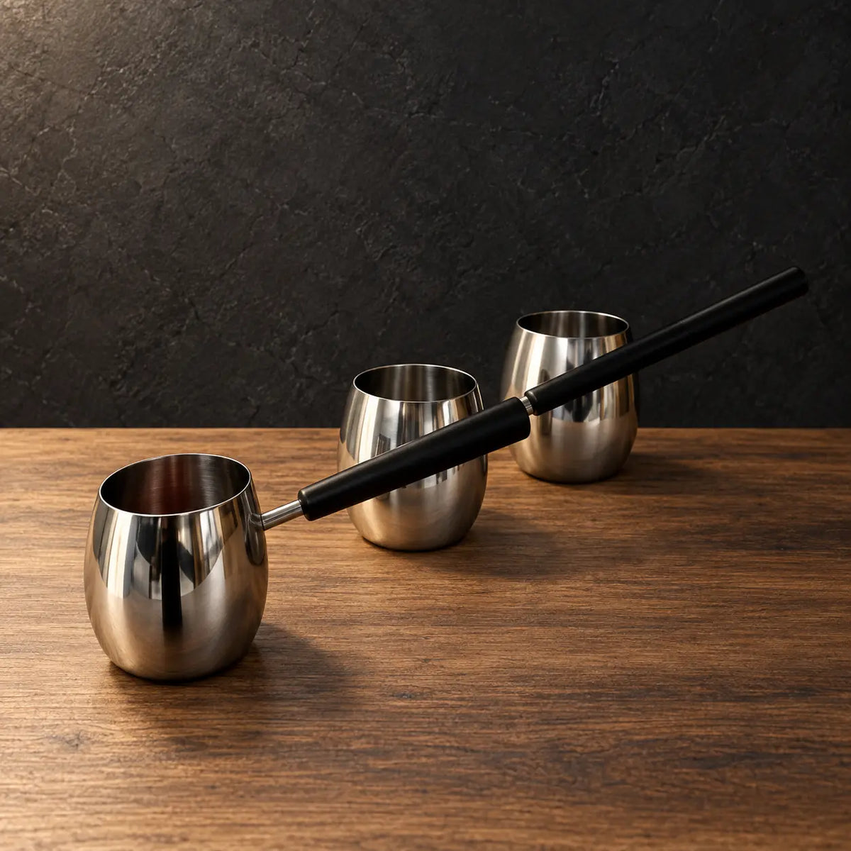 Gold drum-shaped stainless steel milk cups with black handles
