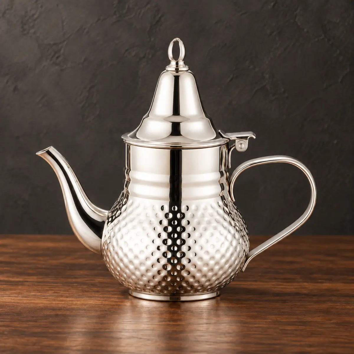 Silver Moroccan kettle with a dotted lower body, conical lid, open ring finial and curved spout