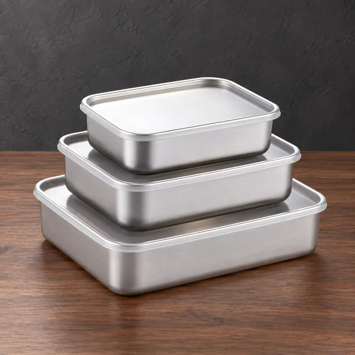 Rectangular food storage container set with two smaller lidded boxes above a low-profile base container