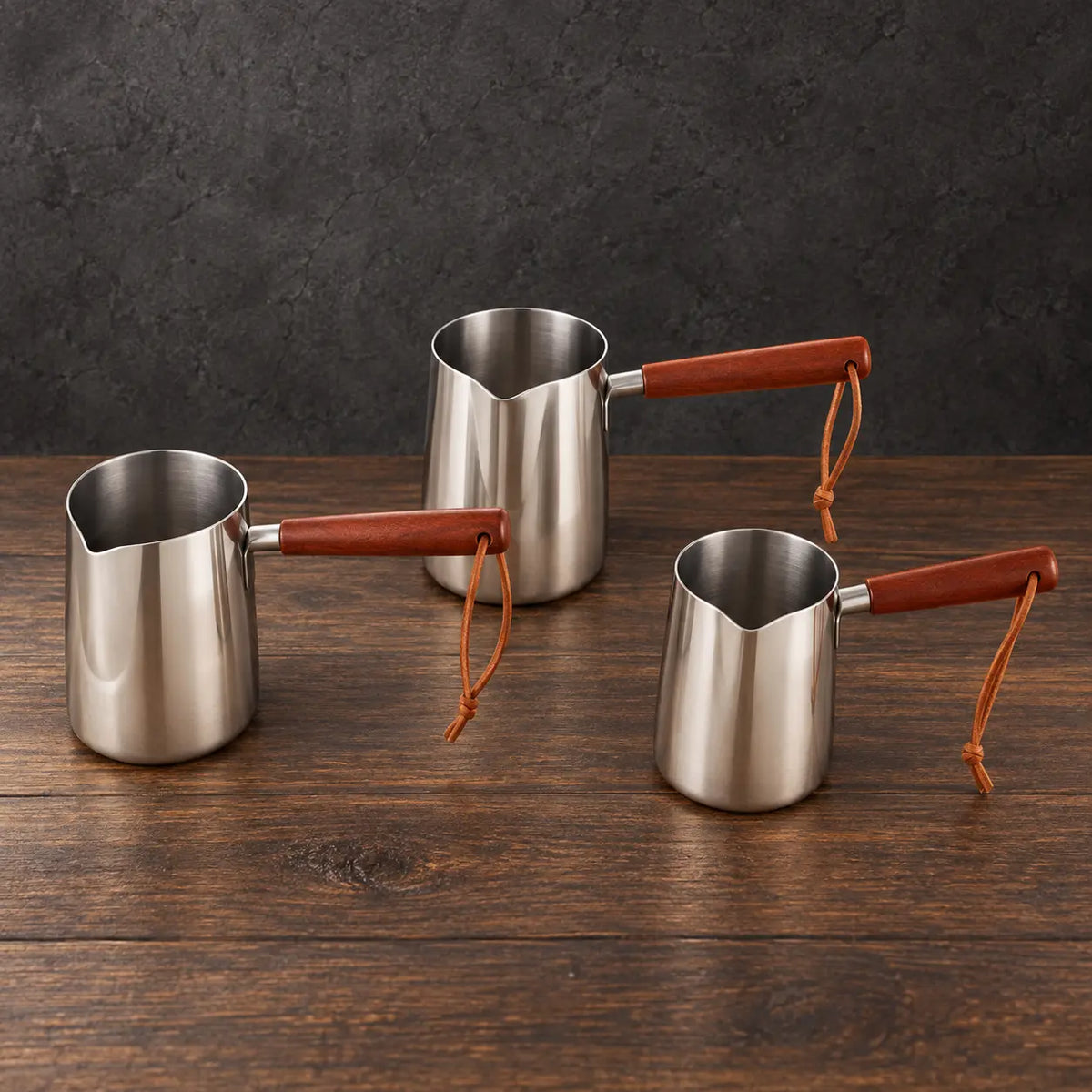 Silver stainless steel milk cups with natural wooden handles and lids