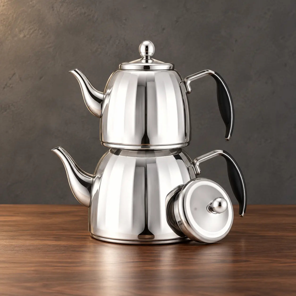 Two silver Star Sparkle kettles with tapered paneled bodies stacked beside a separate round lid
