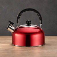 Red thin whistling teapot with a low wide body, black arched handle, black lid knob, and polished lower edge
