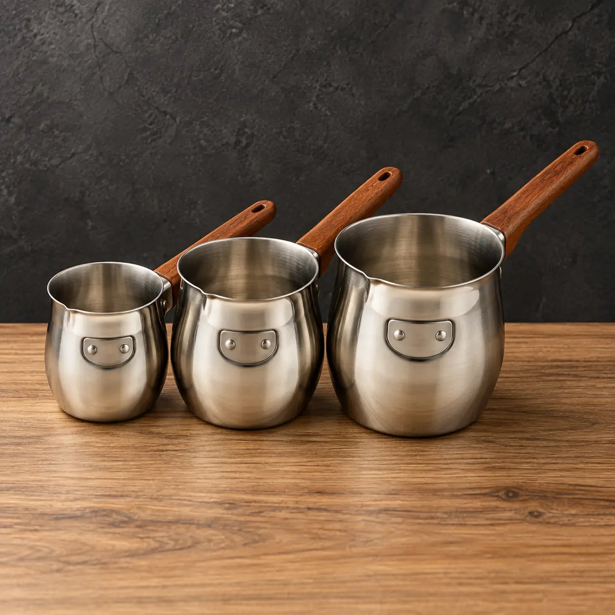 Three stainless steel milk cups with wood-grain handles